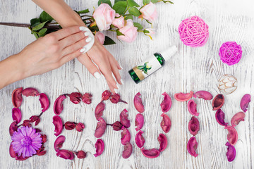 Obraz na płótnie Canvas Beauty female hands with a cotton disc cream lotion flowers