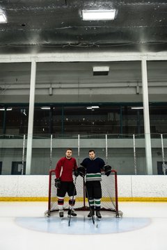 Ice hockey players standing by goal post