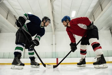 Male hockey players looking face to face at rink