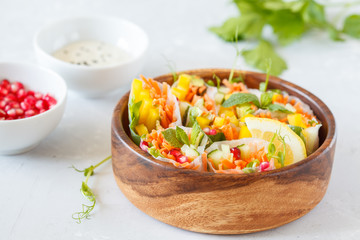 raw spring rolls with vegetables in a wooden bowl