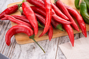 Peperoncini lunghi piccanti rossi sul tagliere di legno