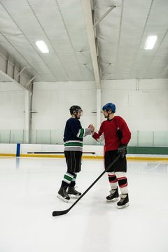 Ice hockey players shaking hands at rink