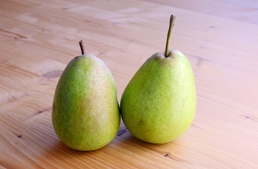 Ripe organic pears on a wooden table, top view.