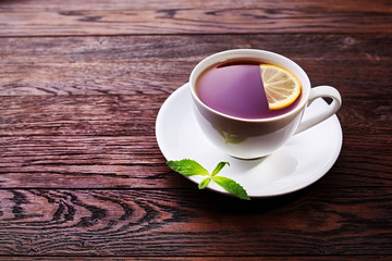 Green tea with lemon and mint on wooden table background