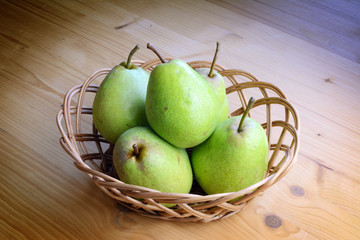 Ripe organic pears on a wooden table, top view.