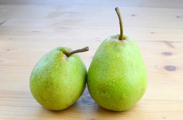 Ripe organic pears on a wooden table, top view.