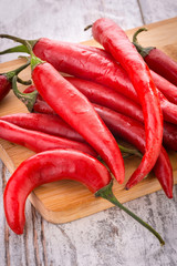 Peperoncini lunghi piccanti rossi sul tagliere di legno