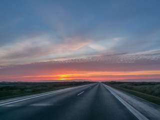Highway on a cold autumn morning with a beautiful sunrise