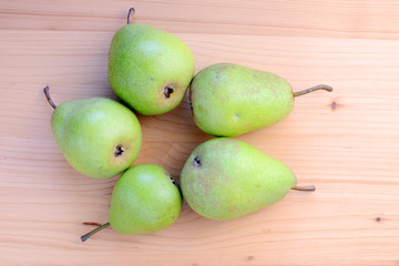 Ripe organic pears on a wooden table, top view.