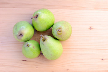 Ripe organic pears on a wooden table, top view.
