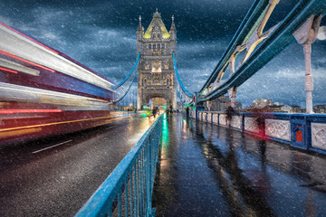 Fototapeta na wymiar Auf der Tower Bridge in London im Herbst mit Schneeregen und vorbeifahrendem, roten Bus