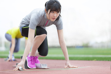 Female student poised at starting block