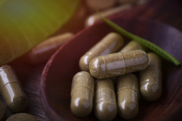 Herbal medicine on wood spool with leaf on wood table