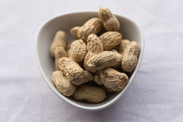 Closeup peanut in white bowl on white background