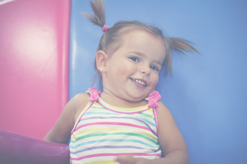 Little Caucasian baby in playground. Happy little baby looking at camera.