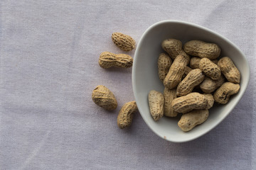 Closeup peanut in white bowl on white background