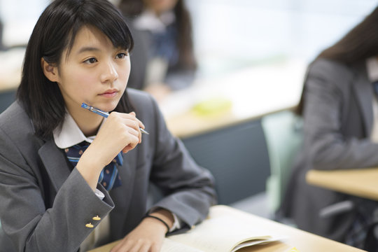 Thoughtful girl sitting in the classroom