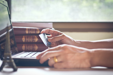 Fototapeta premium Laptop and credit card in man's hand on white table surface,selective focus.Business and finance concept.