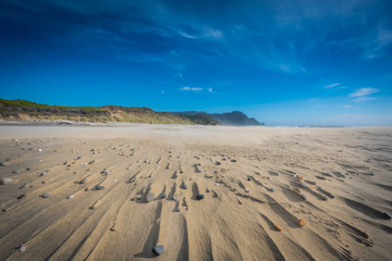 Wispy Clouds Above Stones and Sandy Streaks