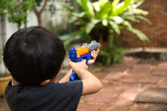 Little boy playing with a toy gun