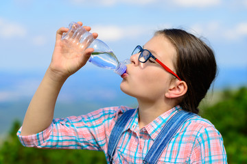 Young girl drinking water outdoor