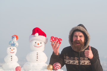 Happy man showing thumbs up hand gesture with present box