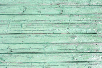 Green wooden background. Rough wooden painted background of boards. Fence close-up.