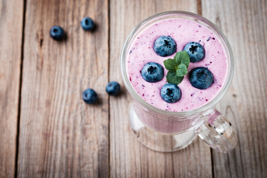 blueberry smoothie with  fresh berries on rustic table