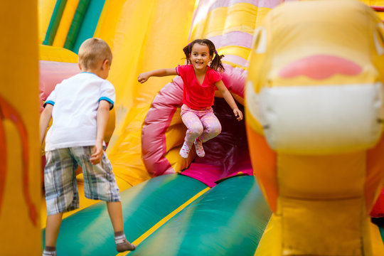 Joyful little girl playing on a trampoline.