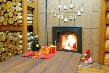 Christmas and New Year decorations at the wood-burning stove in a rural wooden house.