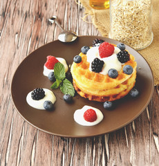 Belgian waffles with berries and honey selective focus