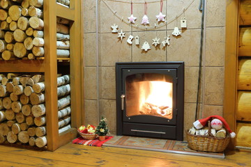 Christmas and New Year decorations at the wood-burning stove in a rural wooden house.