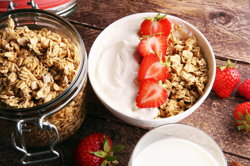 Healthy breakfast concept with oat flakes and fresh berries on rustic background. Food made of granola and musli. Healthy muesli with strawberries, nuts and milk.