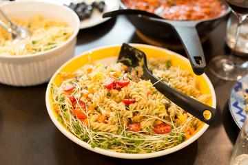 Pasta salad with cherry tomato with sunflower sprouts and parmesan cheese