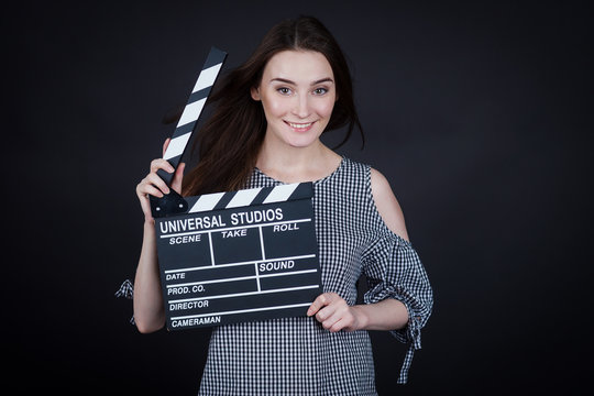 young woman holding a clapperboard cinema