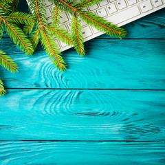 Fototapeta na wymiar Winter christmas green background with green fir tree branch and keyboard