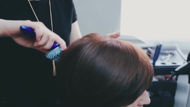 Hairdresser combs the client close up