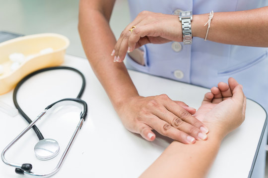 Nurse Is Measurement Radial Pulse At The Wrist Of The Patient.