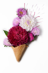 Creative background with chrysanthemum and dahlia flowers in a ice cream cone. Floral border flat lay concept