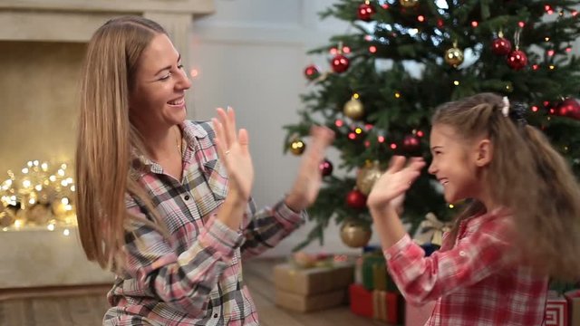 Cute girl playing pat-a-cake with mom on Xmas eve
