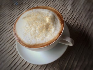 Close up white cappuccino cup on table in vintage tone