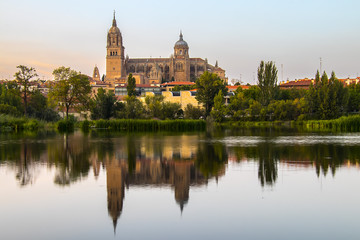 Fototapeta na wymiar Salamanca Old and New Cathedrales reflected on Tormes River at sunset, Spain
