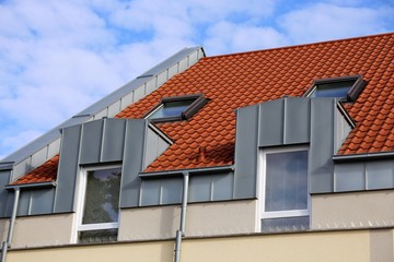 Fototapeta na wymiar Dachgaube mit Edelstahlverkleidung, Dachrinne und Fallrohr