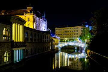 Fototapeta na wymiar Triple Bridge city centre of Ljubljana and the River Ljubljanica illuminated at night, Slovenia