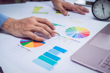 Hands of Businessman working on Laptop Computer with Data Charts