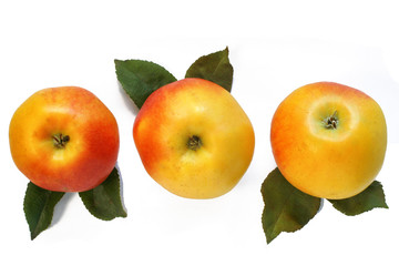 three apples with leaves isolated on white.