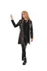 Fototapeta premium full length portrait of girl wearing black clothes with long leather jacket. standing pose on white background.