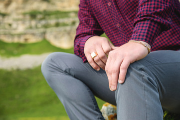 the hand of a man sitting on nature against the background of a rock