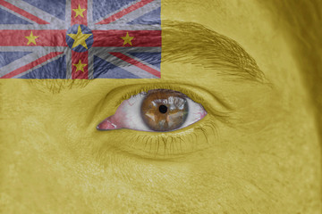 Human face and eye painted with flag of Rock of Polynesia iceland Niue