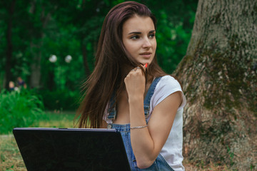 a close-up portrait of young beautiful girls with pensive laptop